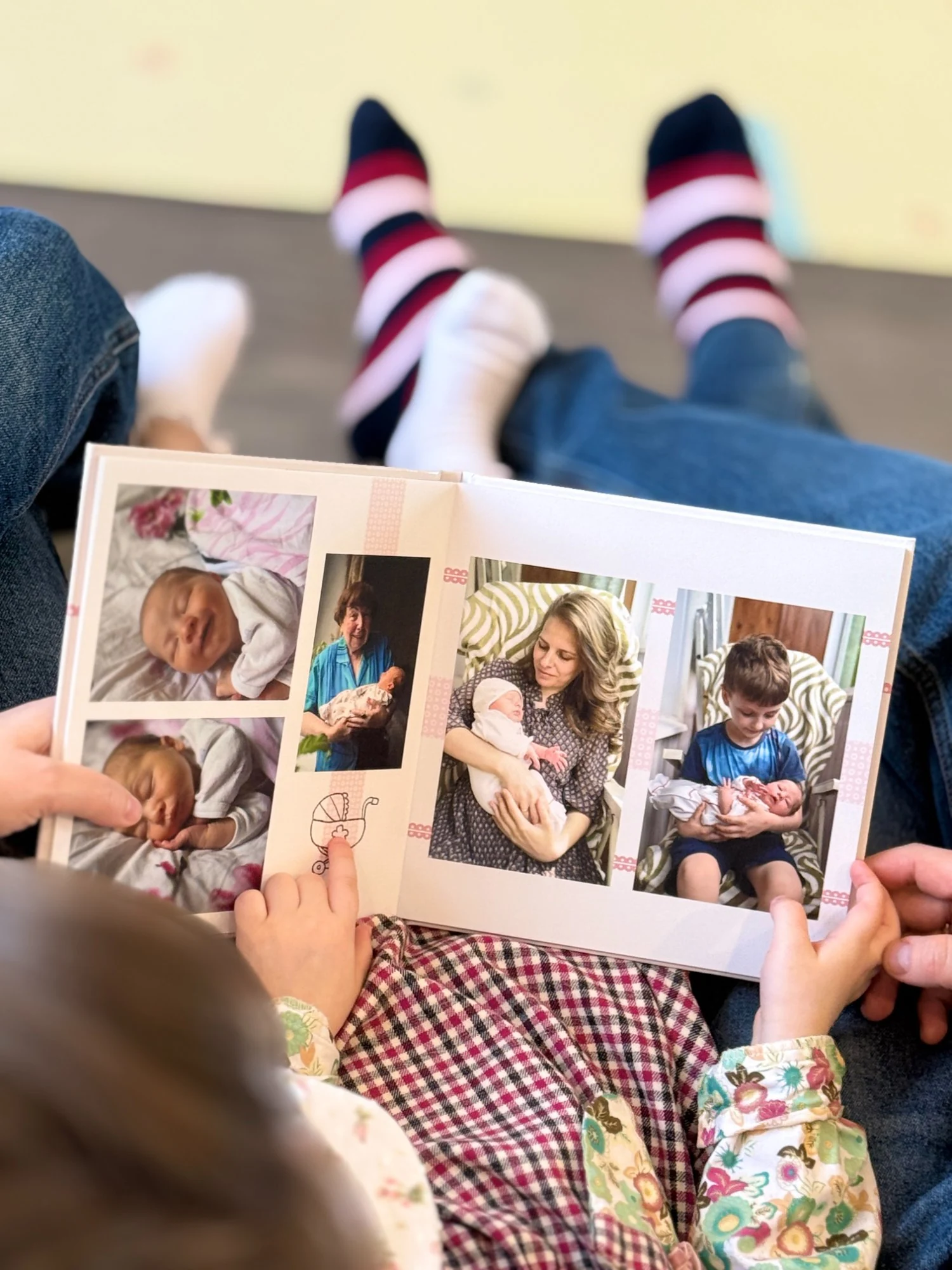 Разворот детской фотокниги — ребёнок держит альбом на коленях